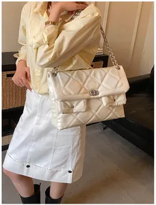Detailed view of the large white quilted crossbody bag with silver chain on a model