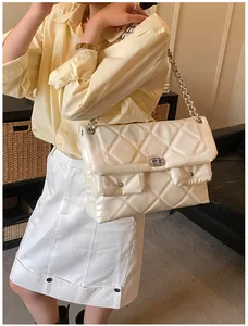 Close-up of beige quilted chain bag featuring glossy finish and silver twist lock detail
