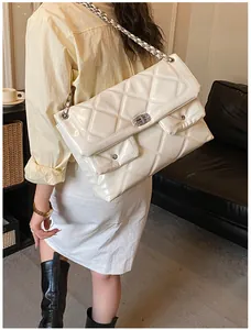 Detail of cream white quilted leather crossbody bag with silver chain and dual pockets