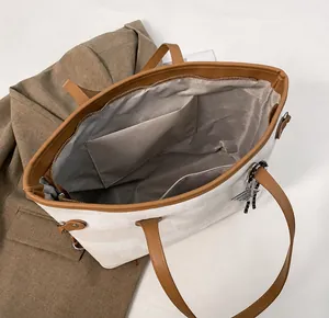 Top view of large tote bag interior showing beige canvas, lining, and zipper pocket