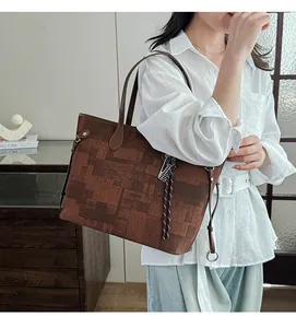 Detail view of large brown tote bag with vintage geometric patterns and round handles