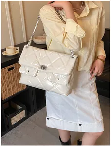 White glossy patent leather shoulder bag featuring quilted texture and silver metal chains