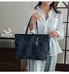 Detail of high capacity tote bag with abstract geometric texture and woven charm