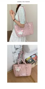 Detail view of pink glossy tote bag with metal buckles and a cute white bunny pendant