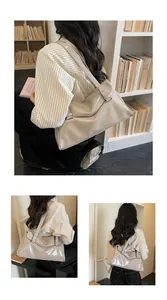 Detail of beige glossy leather tote bag with unique geometric fold and thin shoulder strap