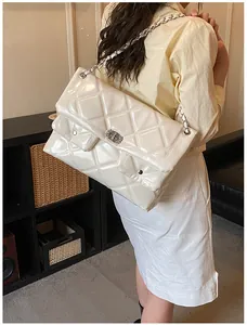 Detail of a beige quilted chain bag featuring glossy finish and double front pockets