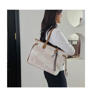 Detail of large beige and brown geometric patterned tote bag with brown leather handles