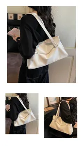 Detail of cream white pleated shoulder bag with adjustable strap and silver metal buckle
