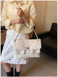 Close-up of beige quilted patent leather crossbody bag with sparkling diamond buckle