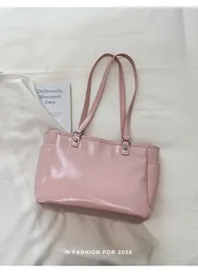 Detail of pink glossy patent leather tote bag with silver hardware and side pockets