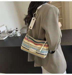 Dettaglio della borsa baguette in paglia colorata con tracolla e catena decorativa