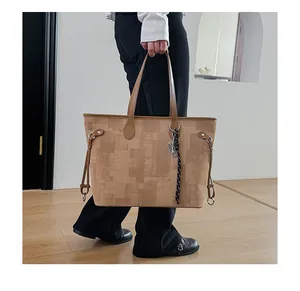 Detail of geometric brown tote bag with woven cord held by model in modern room