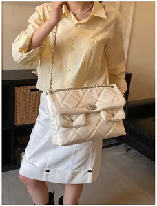 Detail of quilted cream leather shoulder bag with chain strap and dual front pockets