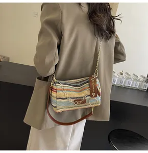 Dettaglio borsa baguette intrecciata arcobaleno con catena e tracolla in pelle marrone