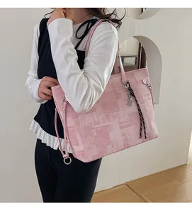 Detail of pink canvas tote bag with abstract prints and metal tag on a model