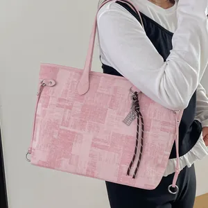 Pink canvas tote bag with geometric patterns and leather trim shown on a model's shoulder