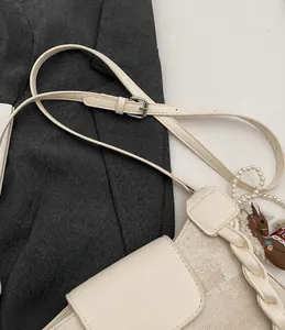 Detail of adjustable leather strap and vintage patchwork shoulder bag with pearl handle