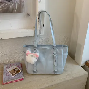 Light blue large capacity tote bag with long straps and cute bunny charm on display