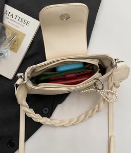 Interior view of beige crossbody bag showing space for phone and pearls detail