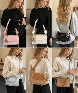 Detail of elegant crossbody bag featuring a braided handle and cute bear pearl pendant