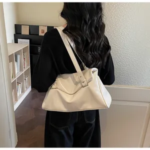 Detail of a shiny cream faux leather tote bag with wide strap and ruched texture style