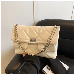 Detail of quilted patent leather texture with silver chain strap and metal turn lock