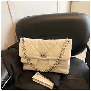 Detailed shot of cream quilted leather bag with silver rhinestone buckle and chain