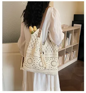 Detail of crochet tote bag with hollow floral pattern and fringe drawstring tassel