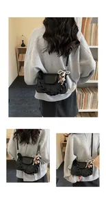 Detail of vintage square crossbody bag with pearl bow charm and braided top handle