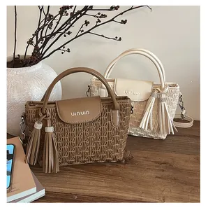Detailed close-up of pleated texture bucket bag with rhinestone tassels and handle