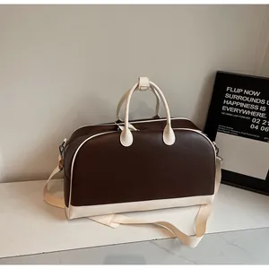 Bolso de viaje retro en cuero contrastado con correa ancha y perfil lateral espacioso