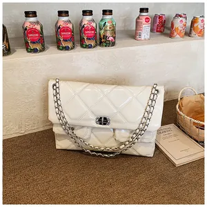 Detail of white quilted patent leather bag with silver chain and crystal clasp