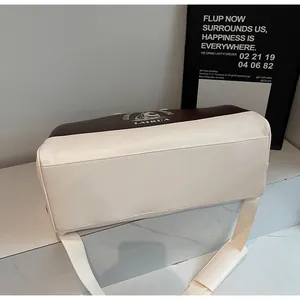 Detalle del bolso de viaje con cuero en contraste marrón y blanco y correa ajustable