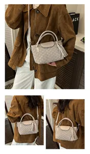 Detail of beige water ripple bucket bag with wave texture and tassel accent