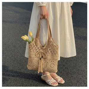 Detail of hand-woven crochet tote bag with fringe drawstrings for summer vacation