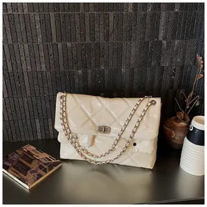 Detail of cream quilted chain bag featuring glossy finish and elegant square twist lock