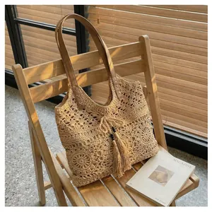 Detailed view of woven tote bag featuring floral crochet patterns and leather straps