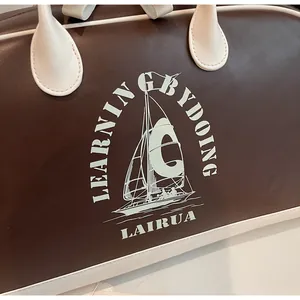 Detalle de bolsa de viaje estilo béisbol vintage con estampado náutico y costuras finas