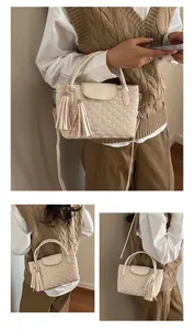 Detail of cream bucket bag with water ripple quilting and elegant tassel charms