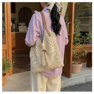Detail of crochet cotton tote bag featuring floral cutout patterns and leather shoulder strap