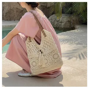 Detail of hand-woven hollow pattern on beige cotton tote bag with brown leather straps