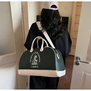 Detalle del bolso de viaje retro estilo béisbol con diseño bicolor y estampado de vela