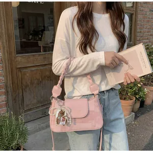Pink vintage square bag with woven strap and pearl horse charm in a cafe setting
