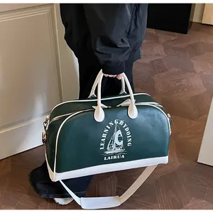 Detalle de bolsa de viaje de cuero verde y blanco con correa ajustable