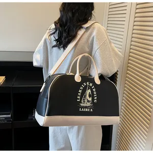 Detalle del bolso de viaje grande bicolor con estampado de velero y correa ancha