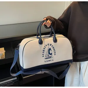 Detalle del estampado de velero y texto en el bolso de viaje retro con asas azules