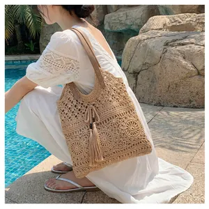 Close-up of hand-woven hollow floral pattern on a beige tote bag with fringe