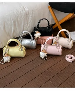 Detail view of mini cylinder Boston bags in five colors with cute plush gnome charms