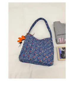 Detailaufnahme der Denim-Tasche mit bunten Karos und orangem Tier-Anhänger
