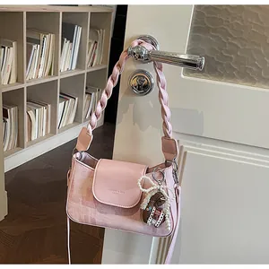 Pink checkered crossbody bag detail with pearl bow charm and plush bear pendant detail